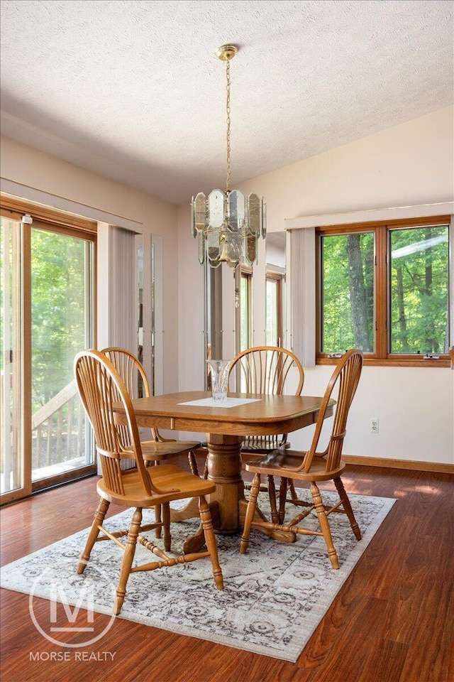 9057 Vergennes St SE, Ada, MI 49301 - dining room with a chandelier, healthy amount of natural light, a textured ceiling, and wood finished floors
