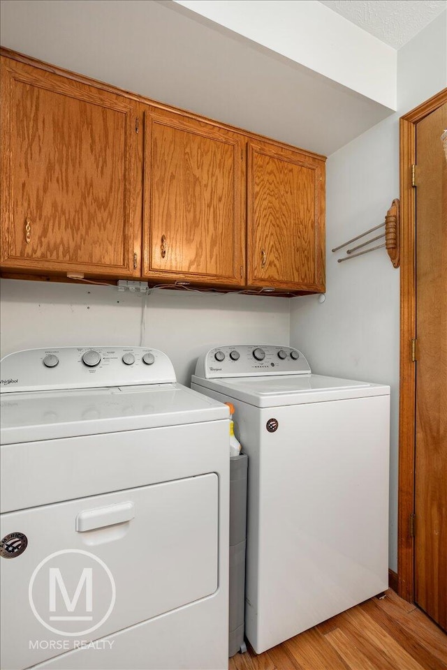 9057 Vergennes St SE, Ada, MI 49301 - laundry area with washing machine and clothes dryer, cabinet space, and light wood-style flooring
