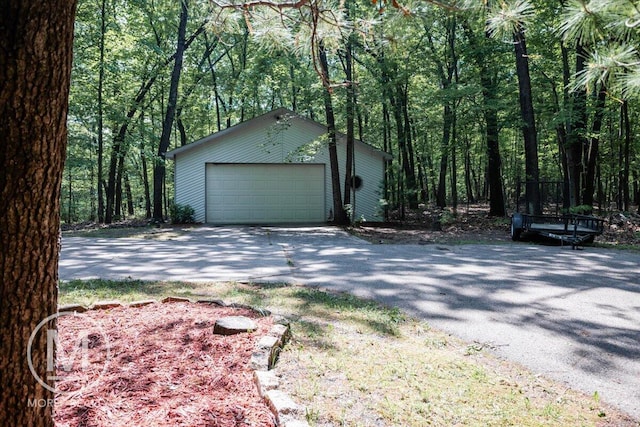 9057 Vergennes St SE, Ada, MI 49301 - detached garage featuring a view of trees and asphalt driveway