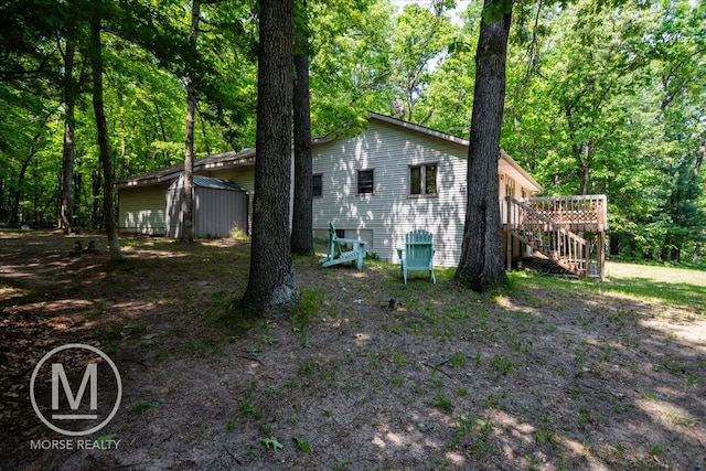 9057 Vergennes St SE, Ada, MI 49301 - rear view of property with stairs, a wooden deck, and a view of trees