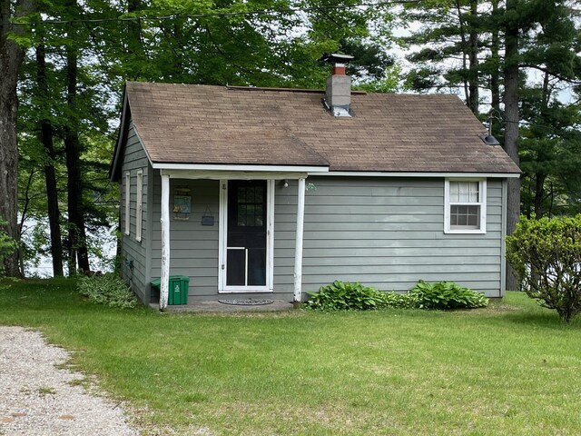 226 N 176th Ave, Walkerville, MI 49459 - back of house featuring a chimney, a lawn, and a shingled roof