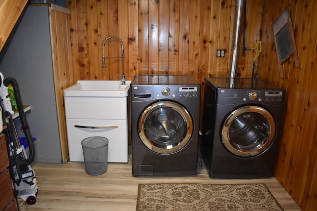 226 N 176th Ave, Walkerville, MI 49459 - washroom with washing machine and clothes dryer, light wood-type flooring, and wooden walls