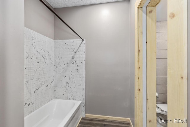 306 W Russell St, Hubbardston, MI 48845 - bathroom with wood finished floors, shower / tub combination, toilet, and baseboards