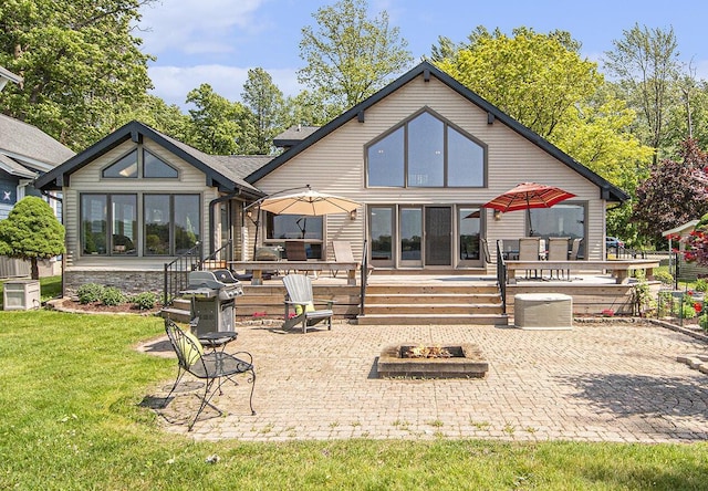 8994 Lenhards Lndg, Clarksville, MI 48815 - rear view of property featuring an outdoor fire pit, a patio area, a yard, and stone siding