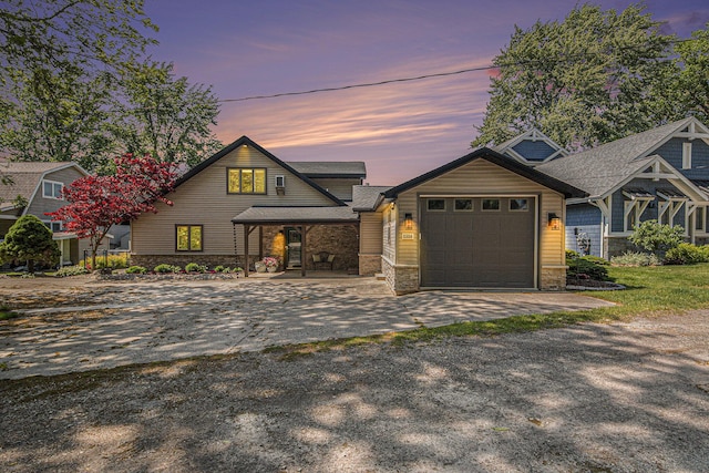 8994 Lenhards Lndg, Clarksville, MI 48815 - view of front of property featuring driveway, an attached garage, stone siding, covered porch, and a shingled roof