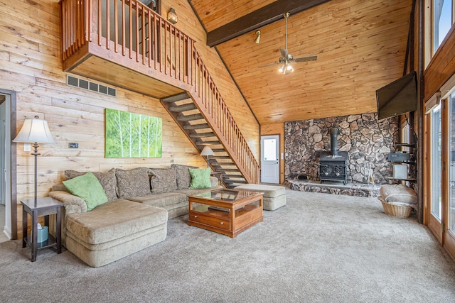 8994 Lenhards Lndg, Clarksville, MI 48815 - living room featuring carpet floors, a wood stove, a wood ceiling with exposed beams, stairway, and high vaulted ceiling