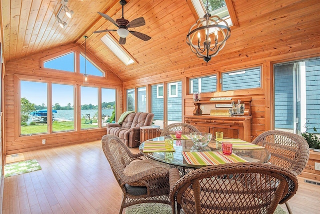 8994 Lenhards Lndg, Clarksville, MI 48815 - dining area featuring a skylight, wood walls, ceiling fan, wood ceiling, and a water view