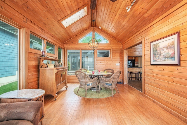 8994 Lenhards Lndg, Clarksville, MI 48815 - dining space featuring a chandelier, wood walls, wooden ceiling, light wood-style floors, and lofted ceiling