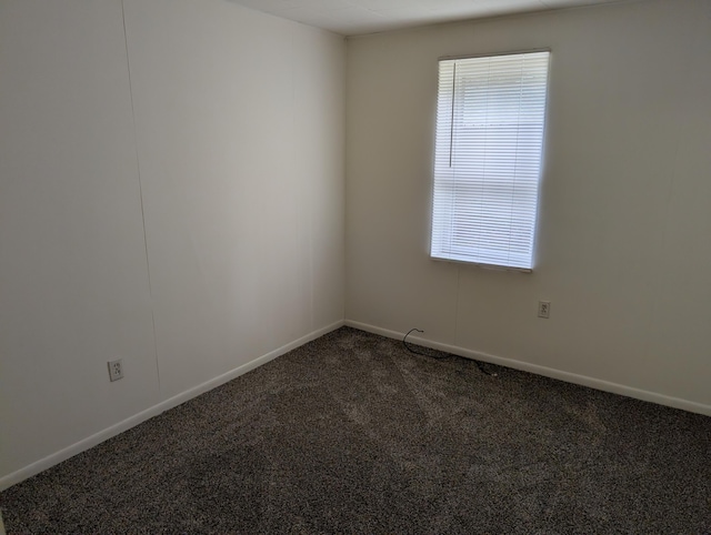 157 S Kenwood St, Muskegon, MI 49442 - empty room featuring dark colored carpet and baseboards