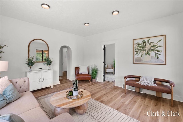 820 Hackett St, Ionia, MI 48846 - living area with arched walkways, wood finished floors, and baseboards