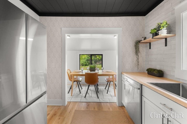 820 Hackett St, Ionia, MI 48846 - kitchen featuring appliances with stainless steel finishes, wallpapered walls, light wood-style flooring, white cabinetry, and open shelves