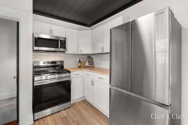 820 Hackett St, Ionia, MI 48846 - kitchen with appliances with stainless steel finishes, light countertops, white cabinetry, light wood-type flooring, and wooden ceiling