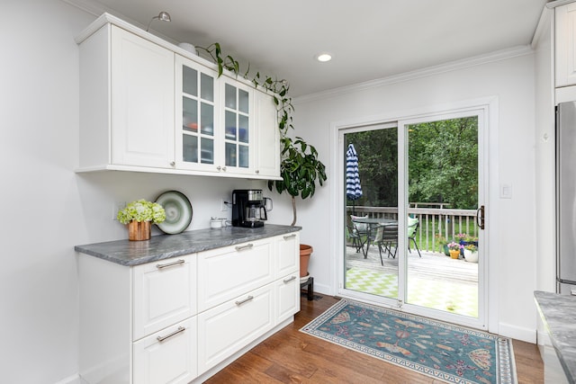 9177 Horseshoe Bnd, Dexter, MI 48130 - bar featuring dark wood-type flooring, crown molding, recessed lighting, freestanding refrigerator, and baseboards