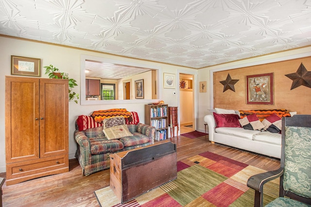8424 3rd St, Onekama, MI 49675 - living area featuring wood finished floors, an ornate ceiling, and ornamental molding
