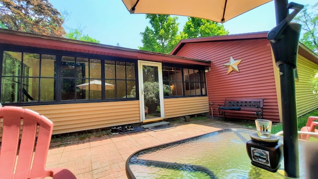 8424 3rd St, Onekama, MI 49675 - back of house with a patio area and a sunroom