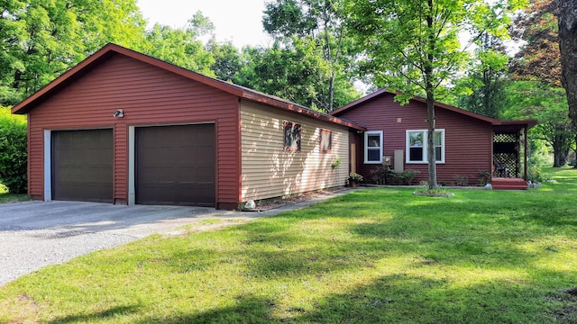 8424 3rd St, Onekama, MI 49675 - view of home's exterior with an outdoor structure, a detached garage, and a yard