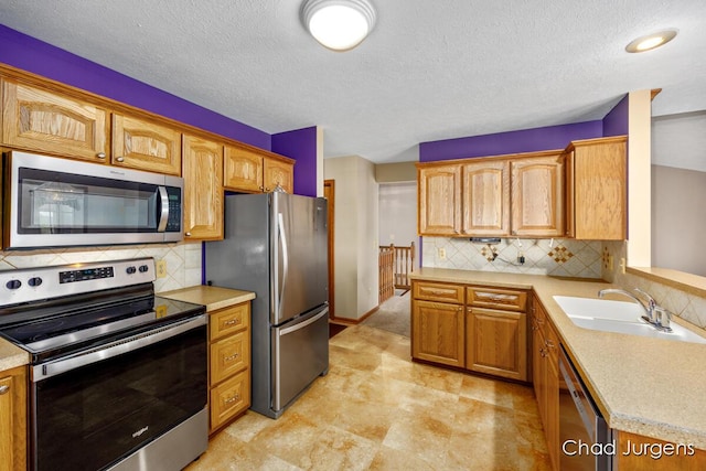 7564 Quincy St, Zeeland, MI 49464 - kitchen featuring appliances with stainless steel finishes, light countertops, decorative backsplash, and a textured ceiling