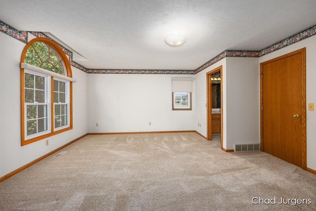 7564 Quincy St, Zeeland, MI 49464 - unfurnished room featuring carpet floors, plenty of natural light, and a textured ceiling
