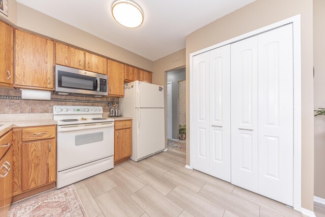 3929 Beech Dr, Ypsilanti, MI 48197 - kitchen with white appliances, light countertops, backsplash, and brown cabinets