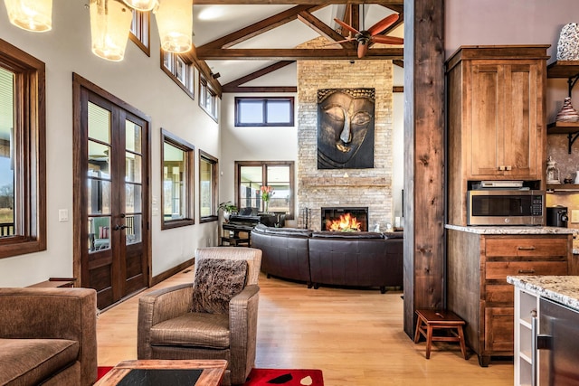 10258 Burgoyne Rd, Berrien Springs, MI 49103 - living room featuring french doors, high vaulted ceiling, light wood-type flooring, beamed ceiling, and a fireplace