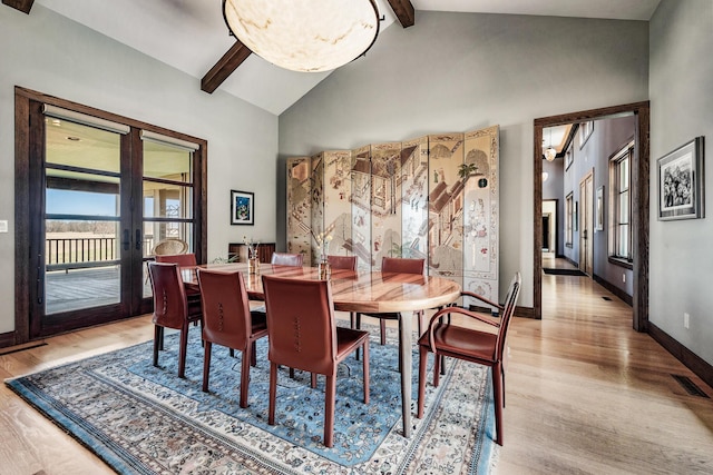 10258 Burgoyne Rd, Berrien Springs, MI 49103 - dining space with french doors, beam ceiling, wood finished floors, baseboards, and high vaulted ceiling