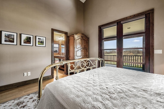 10258 Burgoyne Rd, Berrien Springs, MI 49103 - bedroom featuring access to outside, wood finished floors, baseboards, and a high ceiling