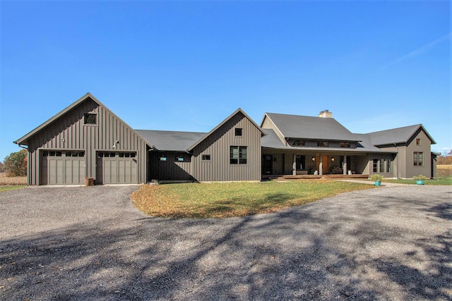 10258 Burgoyne Rd, Berrien Springs, MI 49103 - modern farmhouse style home featuring board and batten siding, a chimney, gravel driveway, a porch, and an attached garage