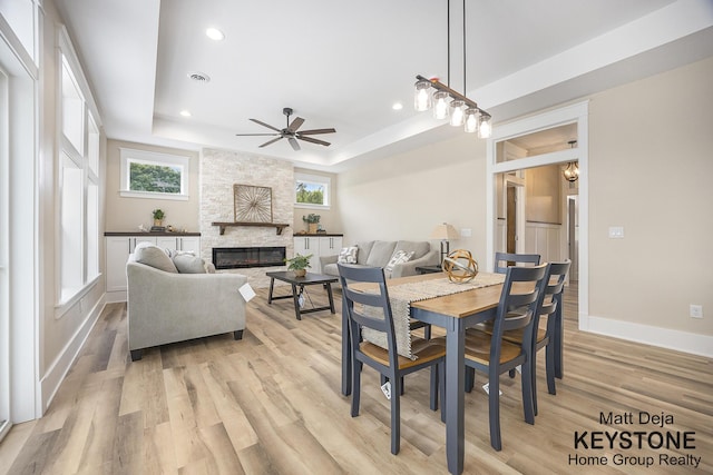 11012 Riverview Dr, Big Rapids, MI 49307 - dining area with a raised ceiling, a ceiling fan, light wood-type flooring, plenty of natural light, and recessed lighting