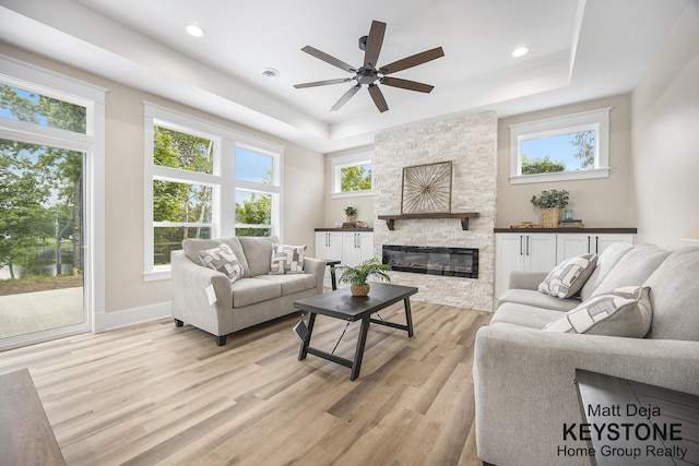11012 Riverview Dr, Big Rapids, MI 49307 - living area with a raised ceiling, plenty of natural light, light wood-style flooring, a ceiling fan, and recessed lighting
