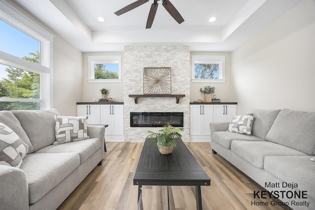 11012 Riverview Dr, Big Rapids, MI 49307 - living room with a raised ceiling, ceiling fan, plenty of natural light, and light wood-type flooring