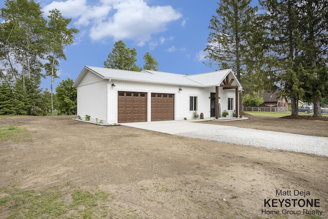 11012 Riverview Dr, Big Rapids, MI 49307 - modern farmhouse featuring a garage, driveway, and a metal roof