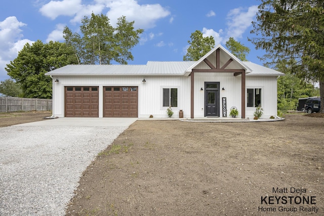 11012 Riverview Dr, Big Rapids, MI 49307 - modern farmhouse with driveway, an attached garage, a metal roof, and board and batten siding