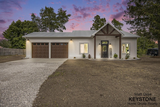 11012 Riverview Dr, Big Rapids, MI 49307 - view of front facade with driveway, a garage, and a metal roof
