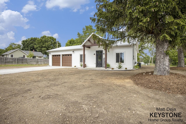 11012 Riverview Dr, Big Rapids, MI 49307 - modern farmhouse featuring concrete driveway and a garage