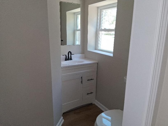 243 Lake Dr, Muskegon, MI 49441 - half bath featuring toilet, vanity, and baseboards