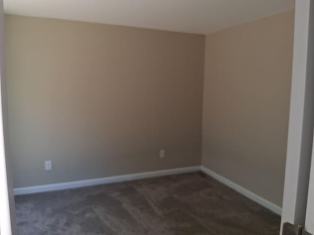 243 Lake Dr, Muskegon, MI 49441 - unfurnished room with dark colored carpet and baseboards