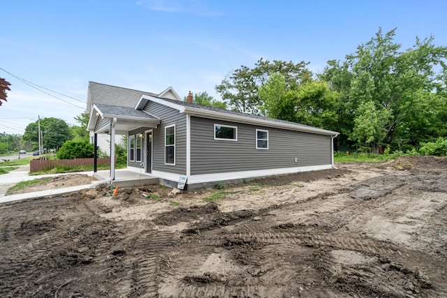 307 N Perrine St, Jackson, MI 49201 - view of side of home featuring a chimney and covered porch