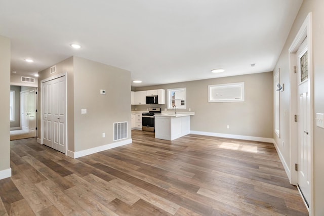 307 N Perrine St, Jackson, MI 49201 - unfurnished living room featuring light wood finished floors and recessed lighting