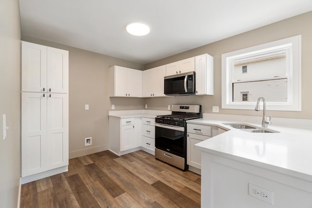 307 N Perrine St, Jackson, MI 49201 - kitchen featuring appliances with stainless steel finishes, dark wood finished floors, light countertops, and white cabinetry