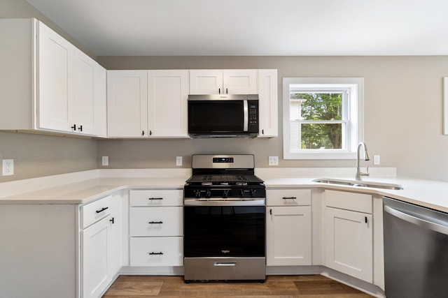 307 N Perrine St, Jackson, MI 49201 - kitchen featuring appliances with stainless steel finishes, white cabinets, light countertops, and light wood-type flooring