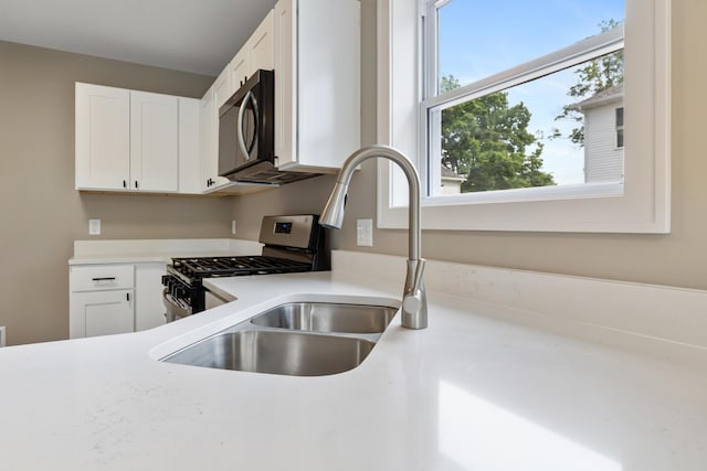 307 N Perrine St, Jackson, MI 49201 - kitchen featuring light countertops, white cabinets, and stainless steel range with gas stovetop