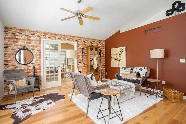 15532 Winchester Cir, Grand Haven, MI 49417 - living area featuring wood finished floors, a ceiling fan, brick wall, and high vaulted ceiling