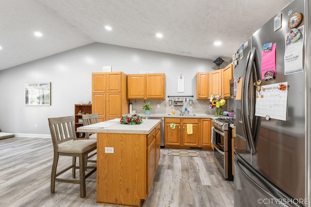 2883 Harmony Ct, Wyoming, MI 49519 - kitchen featuring appliances with stainless steel finishes, light countertops, a center island, a sink, and light wood finished floors