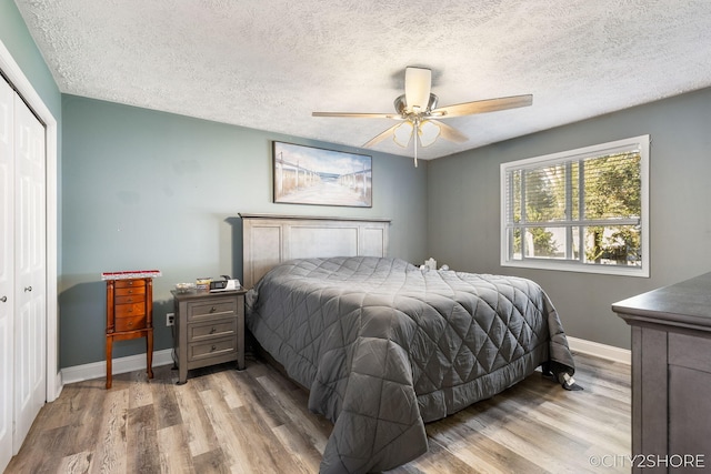 2883 Harmony Ct, Wyoming, MI 49519 - bedroom with wood finished floors, a closet, baseboards, a textured ceiling, and a ceiling fan