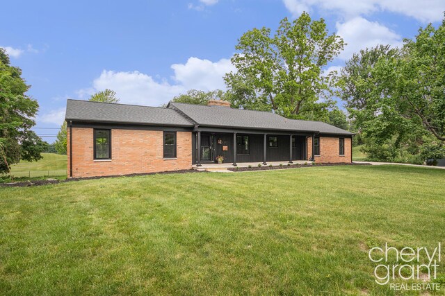 1757 Westlane Dr NE, Grand Rapids, MI 49505 - view of front of house featuring brick siding, a front lawn, and a chimney