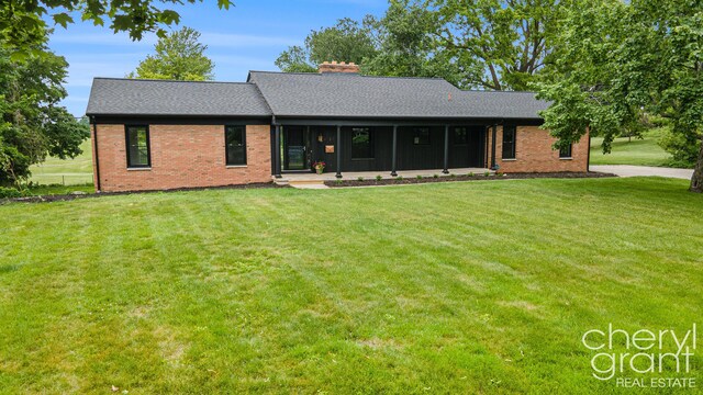 1757 Westlane Dr NE, Grand Rapids, MI 49505 - back of house featuring brick siding, a yard, and a shingled roof