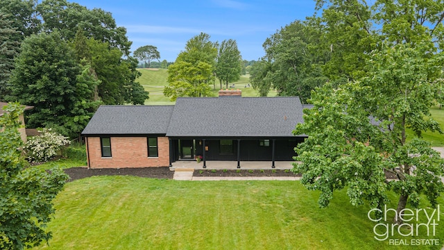 1757 Westlane Dr NE, Grand Rapids, MI 49505 - view of front facade with a shingled roof, a front yard, brick siding, a chimney, and covered porch