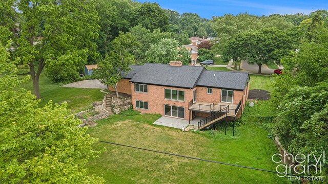 1757 Westlane Dr NE, Grand Rapids, MI 49505 - rear view of house featuring stairs, brick siding, a deck, and a patio