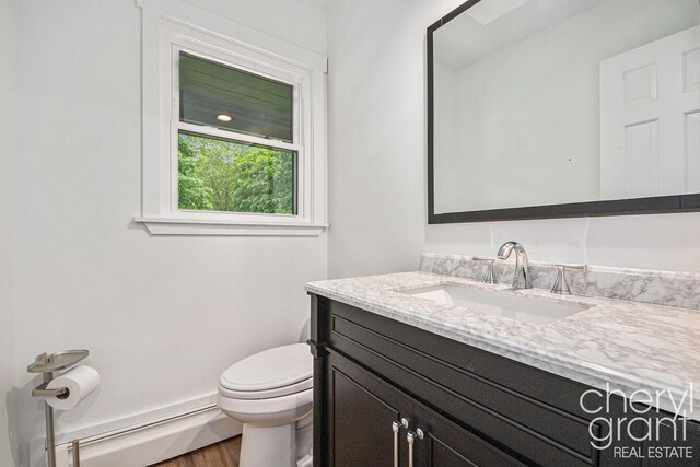 1757 Westlane Dr NE, Grand Rapids, MI 49505 - bathroom featuring a baseboard heating unit, vanity, and wood finished floors