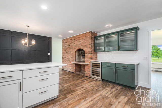 1757 Westlane Dr NE, Grand Rapids, MI 49505 - kitchen with beverage cooler, green cabinets, light countertops, dark wood finished floors, and a chandelier